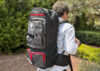 Nokta DetectoBag grey and black metal detecting backpack with red accents worn by a man outdoors.