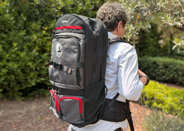Nokta DetectoBag Metal Detecting Backpack Nokta DetectoBag grey and black metal detecting backpack with red accents worn by a man outdoors.